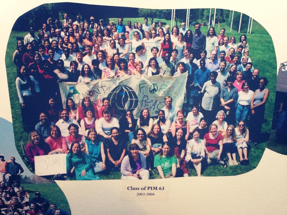 A cut-out photo of a large group of graduates. In the middle, some students are holding a sign that says "Vermont for Peace."